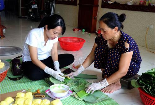 Công đoạn gói bánh phu thê. Ảnh: Đinh Văn Nhiều-TTXVN
