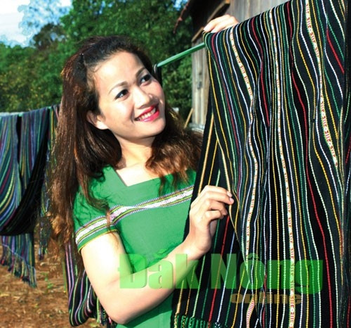 Khác với các tấm vải để may áo, váy, hoa văn trên chiếc khăn địu con của người M’nông được bố trí rất nhỏ, đan xen theo các sọc màu nổi (sáng) của tấm vải