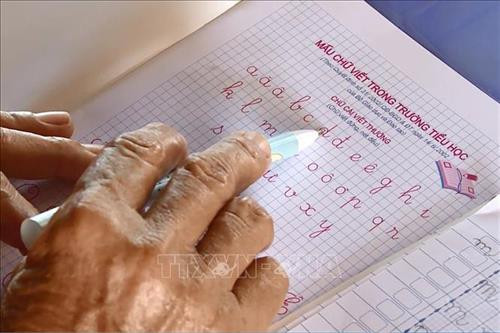 Những bàn tay da nhăn nheo vẫn cố gắng luyện tập từng nét chữ. Ảnh: Lê Xuân-TTXVN