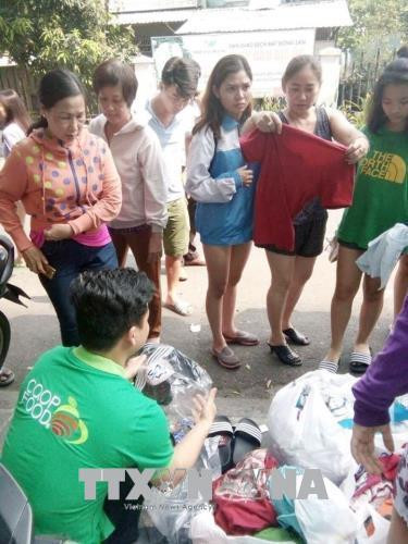 Nhân viên Co.opFood Carina phát quần áo cho người dân gặp nạn. Ảnh: Mỹ Phương- TTXVN