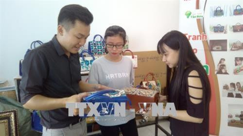 Tấn Bửu (bên trái) đang trao đổi công việc với cộng sự. Ảnh: Ánh Tuyết - TTXVN Tấn Bửu (bên trái) đang trao đổi công việc với cộng sự. Ảnh: Ánh Tuyết - TTXVN