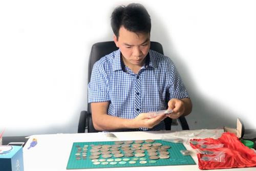 Anh Hoàng Văn Hiền kiểm tra bộ sưu tập đồng bạc.