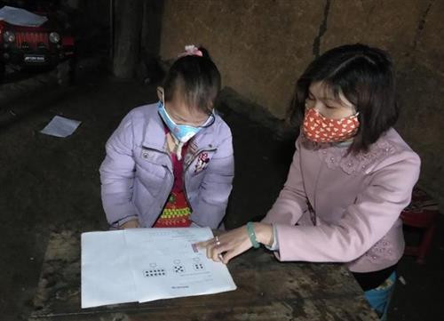 Cô Đàm Thị Nguyên, giáo viên lớp 1, Trường Phổ thông dân tộc bán trú – Tiểu học Thượng Phùng, xã Thượng Phùng, huyện Mèo Vạc (Hà Giang) đang hướng dẫn em Thào Thị Sinh học và ôn bài tập tại nhà. Ảnh: Nguyễn Chiến-TTXVN