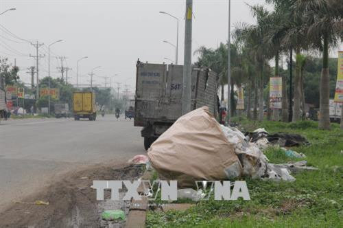 Rác thải tồn ứ trên tuyến đường dẫn vào khu công nghiệp Hải Sơn và khu công nghiệp Tân Đức (huyện Đức Hòa). Ảnh: Bùi Giang – TTXVN