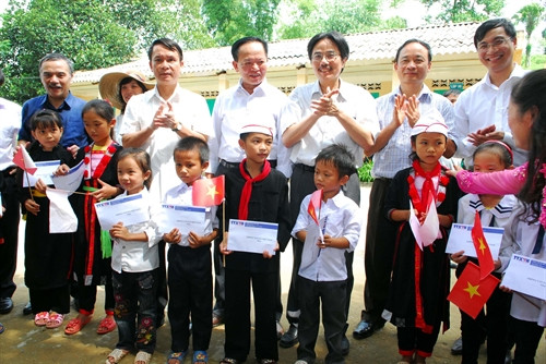 Tổng giám đốc TTXVN Nguyễn Đức Lợi (thứ hai từ trái sang) và các đồng chí trong Ban lãnh đạo TTXVN trao tặng quà là đồ dùng học tập, học bổng và bàn ghế cho học sinh Trường Tiểu học Hoàng Lâu (Tuyên Quang). Ảnh: Danh Lam – TTXVN