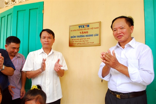 Tổng giám đốc TTXVN Nguyễn Đức Lợi (bên trái) thực hiện nghi thức bàn giao công trình Điểm trường Hoàng Lâu cho Trường Tiểu học Hoàng Lâu, nơi đặt Khu kỷ niệm nơi làm việc của TTXVN tại An toàn khu Tuyên Quang. Ảnh: Danh Lam – TTXVN