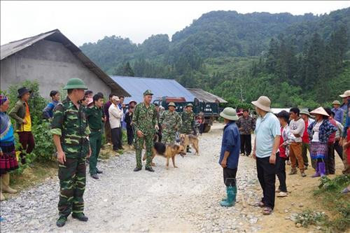 Bộ đội biên phòng Lào Cai huy động lực lượng, chó nghiệp vụ phối hợp với người dân tìm kiếm người bị lạc. Ảnh TTXVN