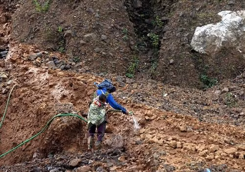 "Phu vàng" dùng nước phun để rửa trôi bùn đất bám trên những viên đá. Ảnh: Phan Tuấn Anh - TTXVN "Phu vàng" dùng nước phun để rửa trôi bùn đất bám trên những viên đá. Ảnh: Phan Tuấn Anh - TTXVN