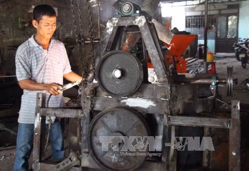 Anh Phi Anh Đệ đang thi công hàn để sản xuất máy công cụ băm rác mía cho khách hàng. Ảnh: Thế Lập - TTXVN.