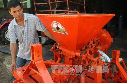 Anh Phi Anh Đệ bên sản phẩm máy công cụ vừa bỏ phân vừa làm cỏ mía do anh sản xuất và chế tạo có năng suất 2 ha/ngày. Ảnh: Thế Lập- TTXVN. Anh Phi Anh Đệ bên sản phẩm máy công cụ vừa bỏ phân vừa làm cỏ mía do anh sản xuất và chế tạo có năng suất 2 ha/ngày. Ảnh: Thế Lập- TTXVN.