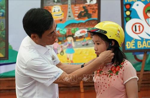 Đại biểu trao mũ bảo hiểm cho các em học sinh. Ảnh: Dư Toán – TTXVN. Đại biểu trao mũ bảo hiểm cho các em học sinh. Ảnh: Dư Toán – TTXVN.
