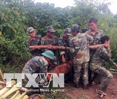 Lực lượng vũ trang huyện Đắk Mil di chuyển, hủy nổ quả bom MK82. Ảnh: TTXVN/phát