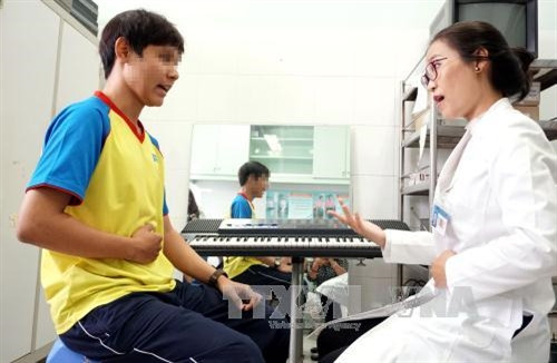 Bác sỹ Trần Thị Thu Trang, Trưởng đơn vị Thanh học Luyện giọng, Bệnh viện Tai Mũi Họng Thành phố Hồ Chí Minh đang điều trị cho bệnh nhân bị rối loạn giọng dậy thì. Ảnh: Phương Vy- TTXVN.