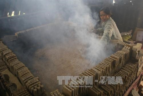 Nung sản phẩm tượng ông Công, ông Táo. Ảnh: Hồ Câu-TTXVN