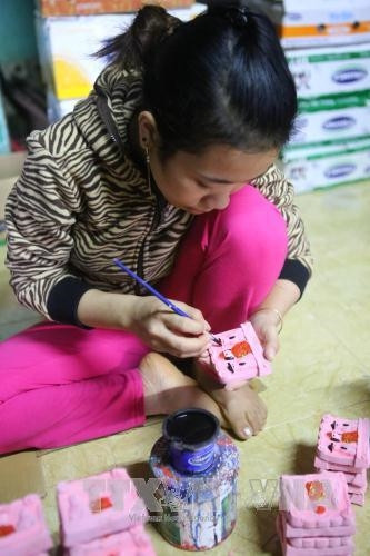 Trang trí cho tượng ông Công ông Táo. Ảnh: Hồ Câu-TTXVN