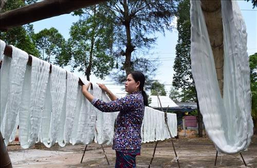 Công đoạn phơi chỉ tại nghề dệt choàng Long Khánh A. Ảnh: Chương Đài - TTXVN