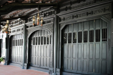 Ngôi nhà cổ được xây từ năm 1799 - Ảnh : Ngọc Tiến. Ngôi nhà được chúa Nguyễn Ánh cho xây dựng vào năm 1799 theo lối kiến trúc truyền thống của Việt Nam với ba gian, hai chái làm nơi trú ngụ cho Giám mục Bá Đa Lộc (quốc tịch Pháp, sinh năm 1741), người dạy học cho hoàng tử Nguyễn Cảnh lúc đó. Ban đầu ngôi nhà được xây dựng bên phần đất của Thảo Cầm Viên bây giờ. Năm 1911, khi Tòa Tổng Giám mục hiện nay được xây dựng hoàn thành, ngôi nhà dời về đây và được giữ gìn, bảo quản đến ngày hôm nay - Ảnh : Ngọc Tiến. Qua những lần di dời trước đó, phần nền đất làm cho cột trụ ngôi nhà bị hư hỏng. Sau đợt trùng tu nền nhà được nâng cao hơn, cột trụ ngôi nhà được đặt trên những tảng đá để đỡ một phần tải trọng và chắc chắn hơn như nguyên bản ngôi nhà ban đầu - Ảnh : Ngọc Tiến. Dàn rui lách, kèo và hệ thống vách được xếp đặt một cách tinh xảo - đó là nét độc đáo và giá trị to lớn về lịch sử và văn hóa ngôi nhà - Ảnh : Ngọc Tiến. Mái nhà được lợp ngói âm dương với những họa tiết hoa văn viền tinh xảo. Hiện nay, lớp ngói đỏ đã được làm mới thay cho lớp ngói cũ rêu phong - Ảnh : Ngọc Tiến. Các cánh cửa làm bằng gỗ quý, hoa văn được điêu khắc tinh xảo tạo thêm nét cổ kính cho mặt tiền của căn nhà - Ảnh : Ngọc Tiến. Ngôi nhà được làm hoàn toàn bằng gỗ quý, khung nhà được liên kết chặt chẽ với nhau hoàn toàn bằng kỹ thuật ghép mộng của những nghệ nhân thời xưa. Hoàn toàn không dùng bất cứ cây đinh nào nhưng ngôi nhà vẫn đứng vững qua hàng trăm năm - Ảnh : Ngọc Tiến. Các nét chạm khắc trên những bộ cửa, vách nhà chưa bị bào mòn và còn nguyên vẹn - Ảnh : Ngọc Tiến. Họa tiết trang trí được khắc họa tỉ mỉ, công phu đặt ngay cửa chính diện tạo sự cân đối và cổ kính, thể hiện nét sáng tạo độc đáo - Ảnh : Ngọc Tiến. Nhiều vật dụng trong nhà như bàn, ghế, tủ, bình phong... vẫn được giữ nguyên vẹn và còn khá tốt. Những chùm đèn được thay mới vì đèn cũ đã hư hỏng, không thể sử dụng được nữa - Ảnh : Ngọc Tiến.