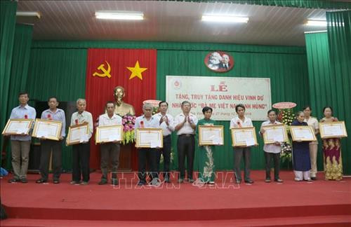 Thân nhân các mẹ nhận bằng truy tặng. Ảnh: Thanh Hòa - TTXVN Thân nhân các mẹ nhận bằng truy tặng. Ảnh: Thanh Hòa - TTXVN