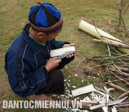 Đồng bào Mông khéo léo đẽo bao đựng dao. Ảnh: Nam Sương