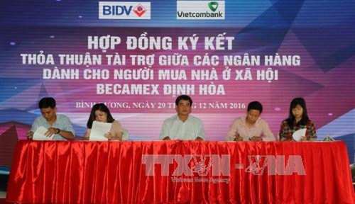 Các gia đình công nhân lao động ký kết vay trả chậm với đại diện các chi nhánh Ngân hàng thương mại ở Bình Dương. Ảnh: Nguyễn Văn Việt - TTXVN Các gia đình công nhân lao động ký kết vay trả chậm với đại diện các chi nhánh Ngân hàng thương mại ở Bình Dương. Ảnh: Nguyễn Văn Việt - TTXVN