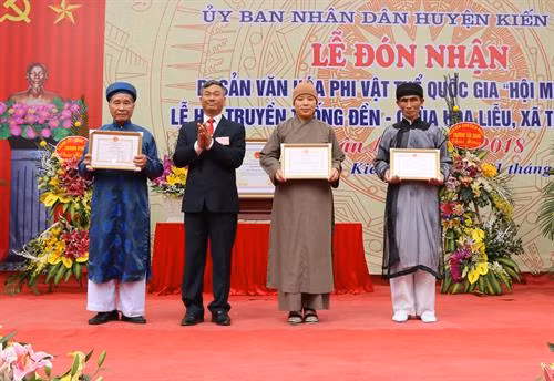 Chủ tịch UBND huyện Kiến Thụy Bùi Đức Thảo trao Bằng khen cho tập thể, cá nhân xuất sắc trong gìn giữ, tổ chức Hội Minh Thề. Ảnh: Minh Thu- TTXVN