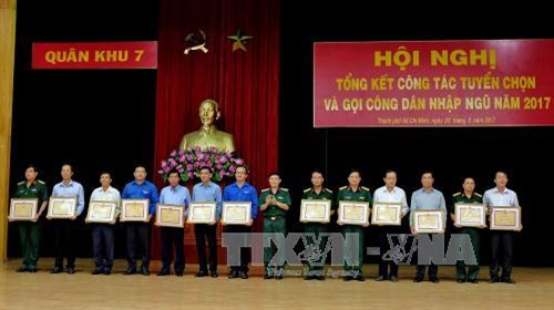 Các cá nhân tiêu biểu làm tốt công tác tuyển chọn và kêu gọi công dân nhập ngũ năm 2017 đón nhận Bằng khen của Bộ Tư lệnh Quân Khu 7. Ảnh: Thế Anh-TTXVN