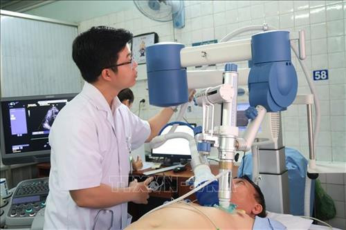 Triển khai kỹ thuật sóng xung kích ngoài cơ thể cho bệnh nhân. Ảnh: Đinh Hằng - TTXVN