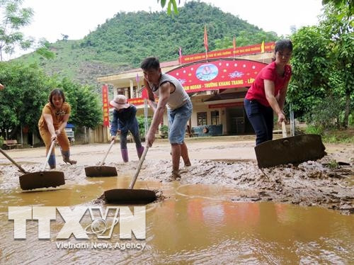 Giáo viên, phụ huynh trường Tiểu học Tân Lang, huyện Phù Yên dọn dẹp bùn đất trên sân trường. Ảnh: Hữu Quyết – TTXVN Giáo viên, phụ huynh trường Tiểu học Tân Lang, huyện Phù Yên dọn dẹp bùn đất trên sân trường. Ảnh: Hữu Quyết – TTXVN