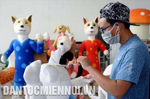 Các công nhân tích cực thực hiện công đoạn tạo hình, vẽ trang trí trên các hình tượng đặc trưng của ngày Tết tại một nhà xưởng của đơn vị thiết kế Đường hoa Nguyễn Huệ 2018. Ảnh: An Hiếu