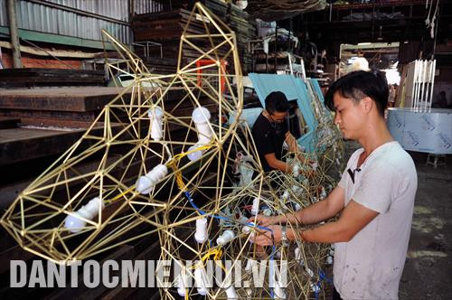 Các công nhân lắp đặt các thiết bị chiếu sáng bên trong mô hình linh vật "Chó Phú Quốc" tại nhà xưởng của một đơn vị thiết kế. Ảnh: An Hiếu