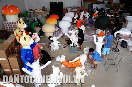 Các công nhân tích cực thực hiện công đoạn tạo hình, vẽ trang trí trên các hình tượng đặc trưng của ngày Tết tại một nhà xưởng của đơn vị thiết kế Đường hoa Nguyễn Huệ 2018. Ảnh: An Hiếu