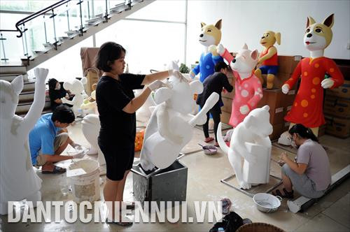 Các công nhân tích cực thực hiện công đoạn tạo hình, vẽ trang trí trên các hình tượng đặc trưng của ngày Tết tại một nhà xưởng của đơn vị thiết kế Đường hoa Nguyễn Huệ 2018. Ảnh: An Hiếu