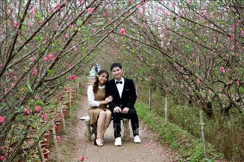 Hoa đào nở sớm còn là dịp để các cặp đôi lên vườn đào Nhật Tân ngắm cảnh, chụp ảnh. Ảnh: Khánh Hòa - TTXVN