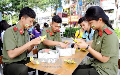 Các thanh niên Công an nhân dân tham gia tạo hình hoa hướng dương tại ngày hội. Ảnh: An Hiếu – TTXVN