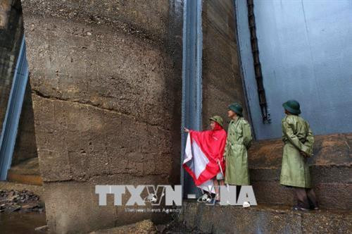 Cán bộ quản lý hồ chứa nước Kẻ Gỗ đi kiểm tra các vị trí có hiện tượng hư hỏng. Ảnh: Thành Đạt – TTXVN