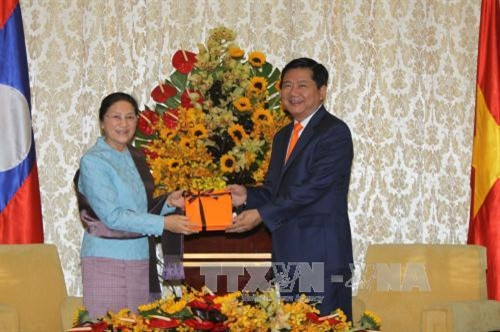 Bí thư Thành ủy Thành phố P Hồ Chí Minh Đinh La Thăng tặng hoa và quà Chủ tịch Quốc hội Lào Pany Yathotou nhân dịp Ngày Quốc tế Phụ nữ 8/3. Ảnh: Thanh Vũ-TTXVN