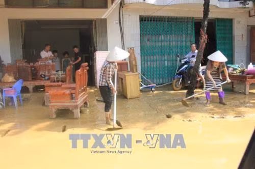 Người dân nỗ lực khắc phục hậu quả do mưa lũ. Ảnh: Tạ Toàn - TTXVN