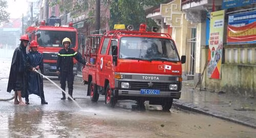 Lực lượng Công an hỗ trợ người dân dọn vệ sinh sau lụt. Ảnh: Tường Vi - TTXVN