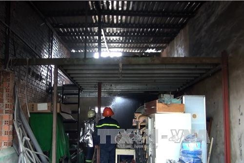 Cảnh sát PCCC phun nước dập tắt ngọn lửa trong ngôi nhà do xe ô tô bốc cháy gây ra. Ảnh: Mạnh Linh-TTXVN