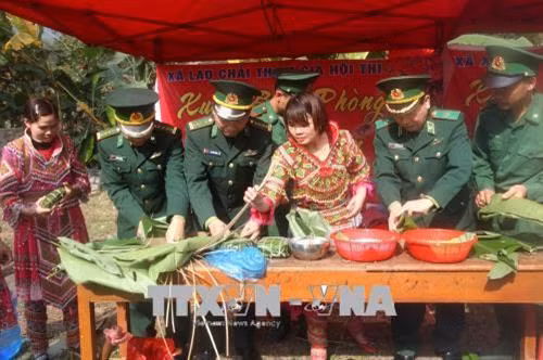 Cán bộ chiến sỹ Bộ đội Biên phòng Hà Giang gói bánh trưng cùng bà con dân tộc thiểu số. Ảnh: Minh Tâm - TTXVN