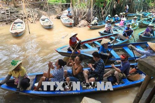Khách quốc tế khám phá miền sông nước Tiền Giang. Ảnh: Ngọc Hà - TTXVN Khách quốc tế khám phá miền sông nước Tiền Giang. Ảnh: Ngọc Hà - TTXVN