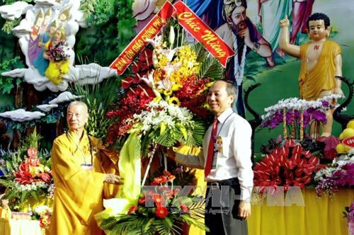 Trưởng lão Hòa thượng Thích Trí Quảng (trái), Phó Pháp chủ GHPGVN, đón nhận lẵng hoa chúc mừng từ đại diện Ban tôn giáo Chính phủ tại buổi lễ mừng Phật Đản. Ảnh: Thế Anh – TTXVN.