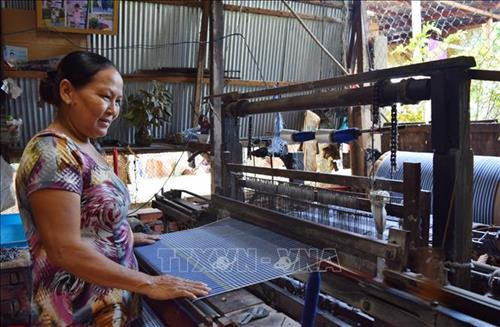 Dệt khăn choàng tại hộ sản xuất của gia đình bà Nguyễn Thị Mèn. Ảnh: Chương Đài - TTXVN