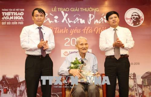 Tổng Giám đốc Thông tấn xã Việt Nam Nguyễn Đức Lợi và Phó Chủ tịch UBND Thành phố Hà Nội Ngô Văn Quý trao Giải thưởng lớn - Vì Tình Yêu Hà Nội năm 2018 cho ông Nguyễn Bá Đạm với những cống hiến suốt đời cho văn hóa, lối sống Hà Nội. Ảnh: Dương Giang - TTXVN