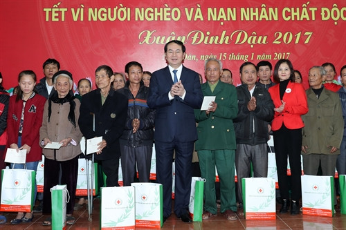 Chủ tịch nước Trần Đại Quang thăm hỏi, tặng quà và chúc Tết các gia đình chính sách của hai xã Nam Giang, Nam Lĩnh (huyện Nam Đàn). Ảnh: Nhan Sáng-TTXVN