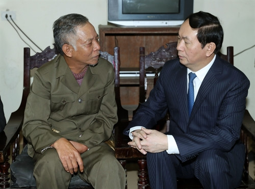 Chủ tịch nước Trần Đại Quang thăm hỏi, tặng quà và chúc Tết thương binh nặng Đặng Văn Thân ở xóm Thuận 1, xã Hưng Hoà, thành phố Vinh. Ảnh: Nhan Sáng-TTXVN
