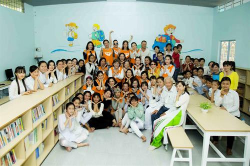 Các thành viên Câu lạc bộ Open Arms với các giáo viên, học sinh tại thư viện mới do Câu lạc bộ hỗ trợ