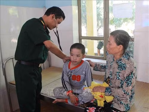 Cán bộ Bệnh xã Quân dân y, Đoàn Kinh tế-Quốc phòng 737 khám bệnh miễn phí cho tre em xã Ia R’vê, huyện Ea Súp. Ảnh: Phạm Cường-TTXVN