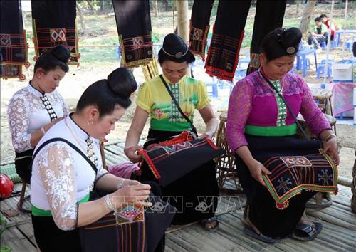 Phụ nữ dân tộc Thái ở Tây Bắc trong trang phục truyền thống (váy, áo cóm, tằng cẩu) đang thêu thùa, may vá thổ cẩm. Ảnh: Xuân Tiến – TTXVN Phụ nữ dân tộc Thái ở Tây Bắc trong trang phục truyền thống (váy, áo cóm, tằng cẩu) đang thêu thùa, may vá thổ cẩm. Ảnh: Xuân Tiến – TTXVN