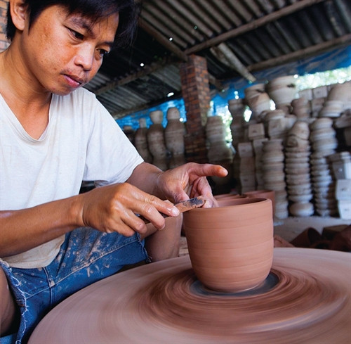 Tạo hình sản phẩm gốm trên bàn xoay.